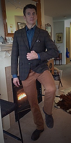A man in a dark blue or denim shirt and brown pants