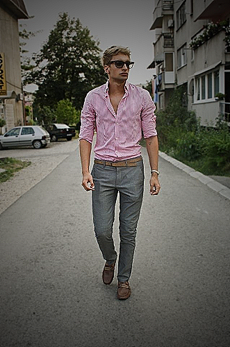 A man in a light pink shirt and brown pants