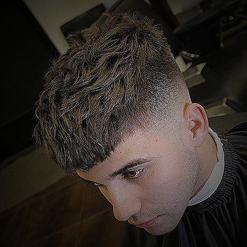 An example of a 3 to 1 fade haircut featuring a high bald fade with messy, textured hair