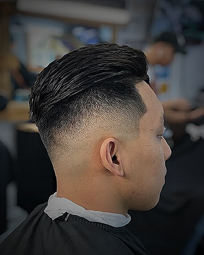 An example of a 3 to 1 fade haircut featuring a low skin fade with a slicked back undercut