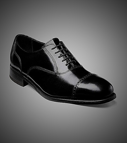 Black cap-toe Oxford shoes with dark jeans