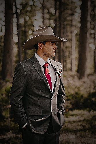 A man wearing a colorful suit and cowboy hat
