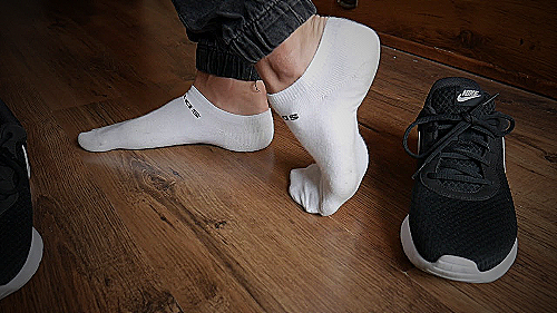 Pair of white sneakers and black ankle socks
