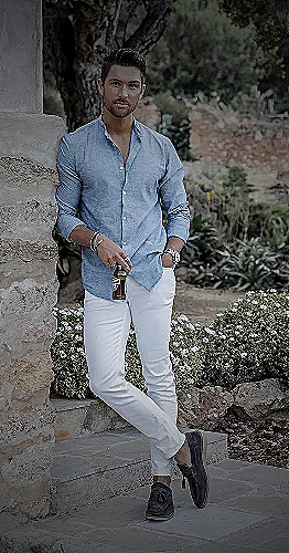 A man wearing a white shirt and white pants, standing outside - how to wear white pants men
