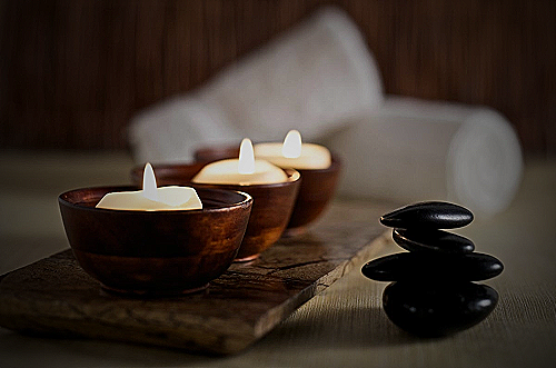 Image of a spa day with candles and a massage table - me vas a echar de menos