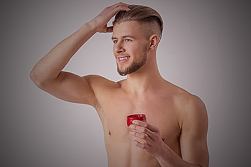 Man styling his hair using a comb and hair gel - how often should you get a haircut men