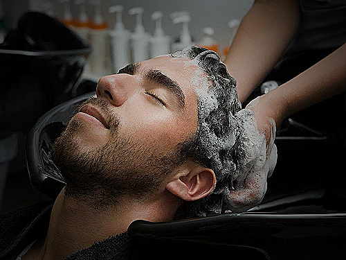 Man with thinning hair gently washing his hair with a brush - how to wash hair men