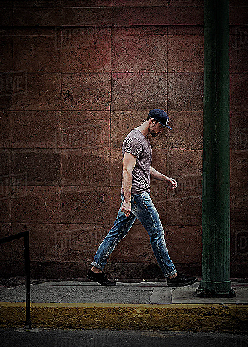 man walking on the outside of a sidewalk